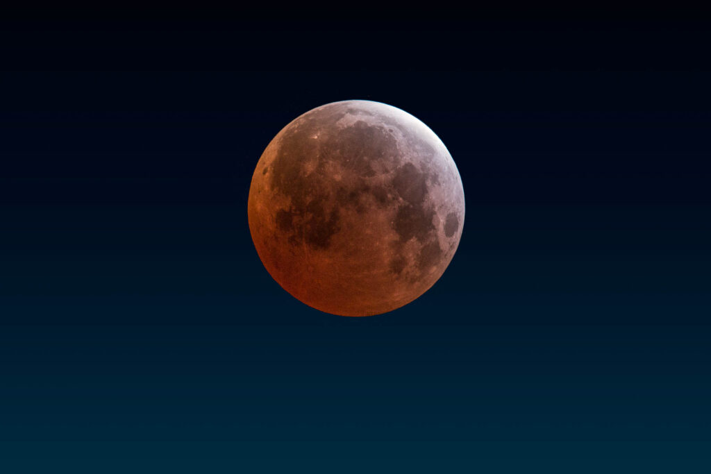 Lunar eclipse with reddish moon against dark sky