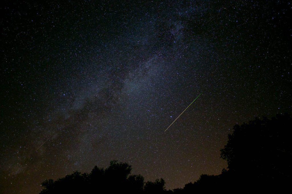 Starry night sky with meteor streaking.