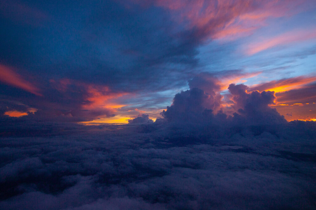 Dramatic clouds at colorful sunset over ocean