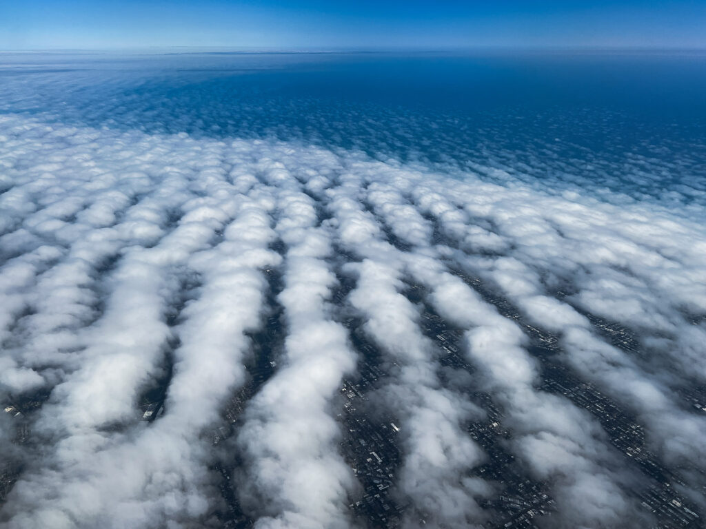 Aerial view of striped cloud pattern over landscape.