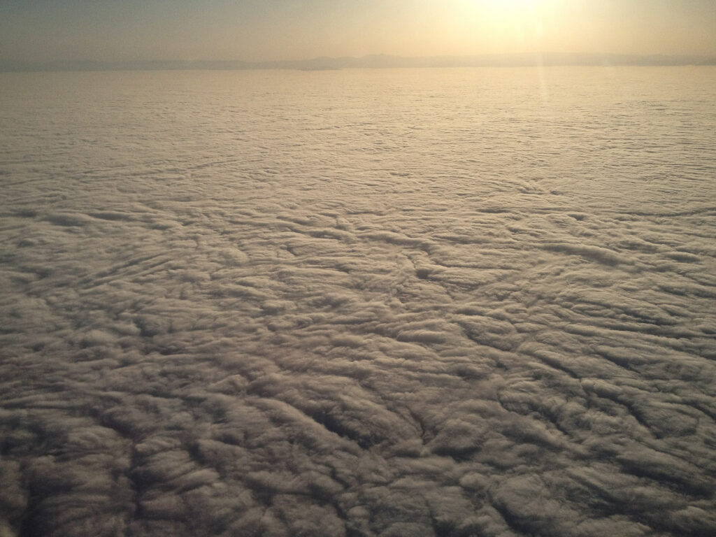 Aerial view of cloud-covered landscape at sunrise.