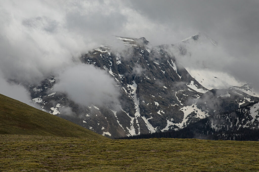 Snowy mountain peaks partially covered by clouds.