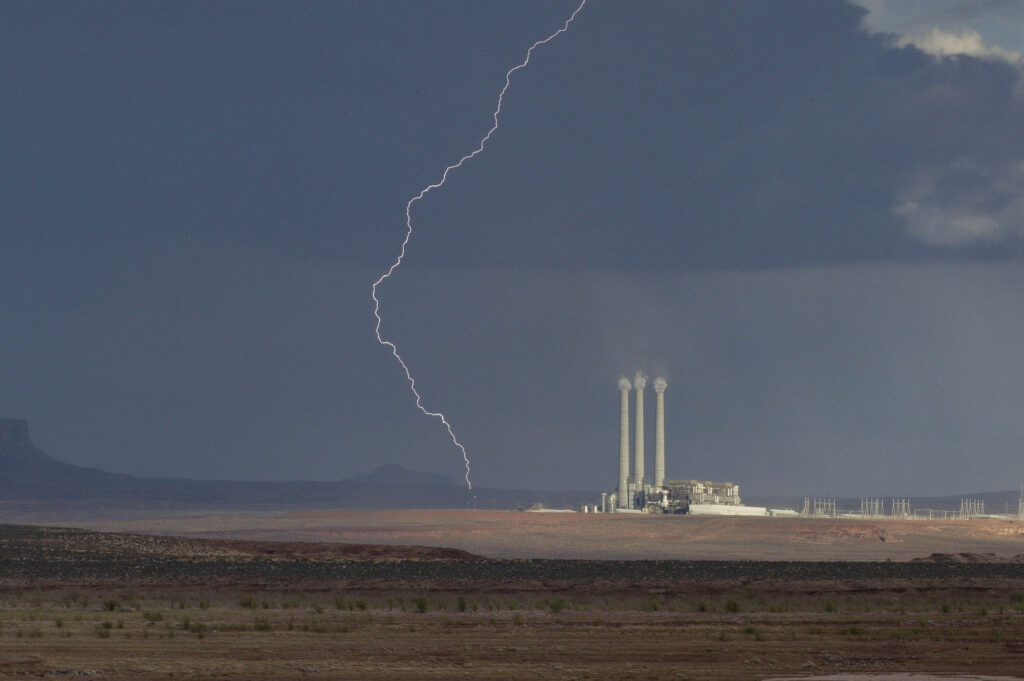 Lightning over power plant in desert landscape